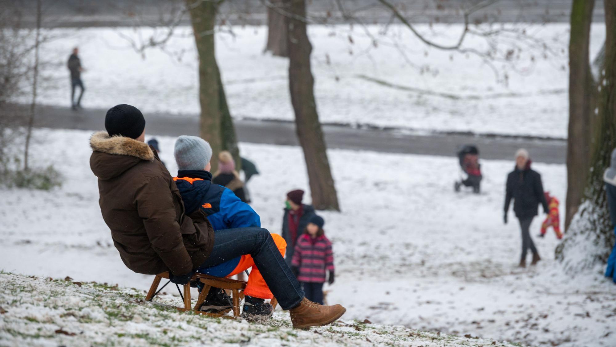 Kinder fahren Schlitten am Aachener Weiher.
