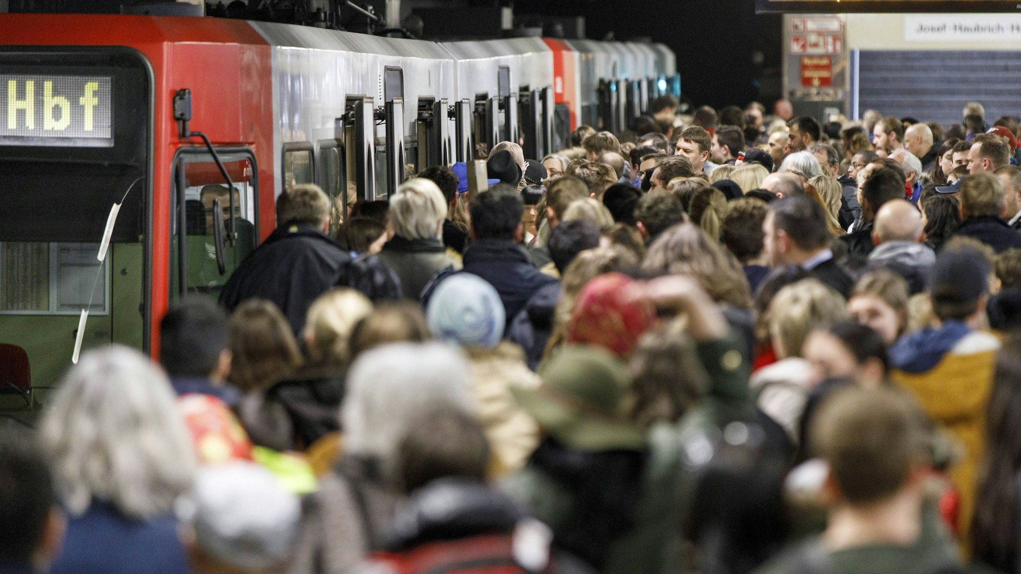 Dicht gedrängt stehen zahlreiche Fahrgäste auf dem Bahnsteig der U-Bahn-Haltestelle Neumarkt. Einige versuchen, eine KVB-Bahn zu besteigen.
