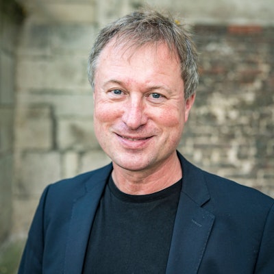 Stefan Kraus steht vor einer Mauer im Innenhof von Kolumba.