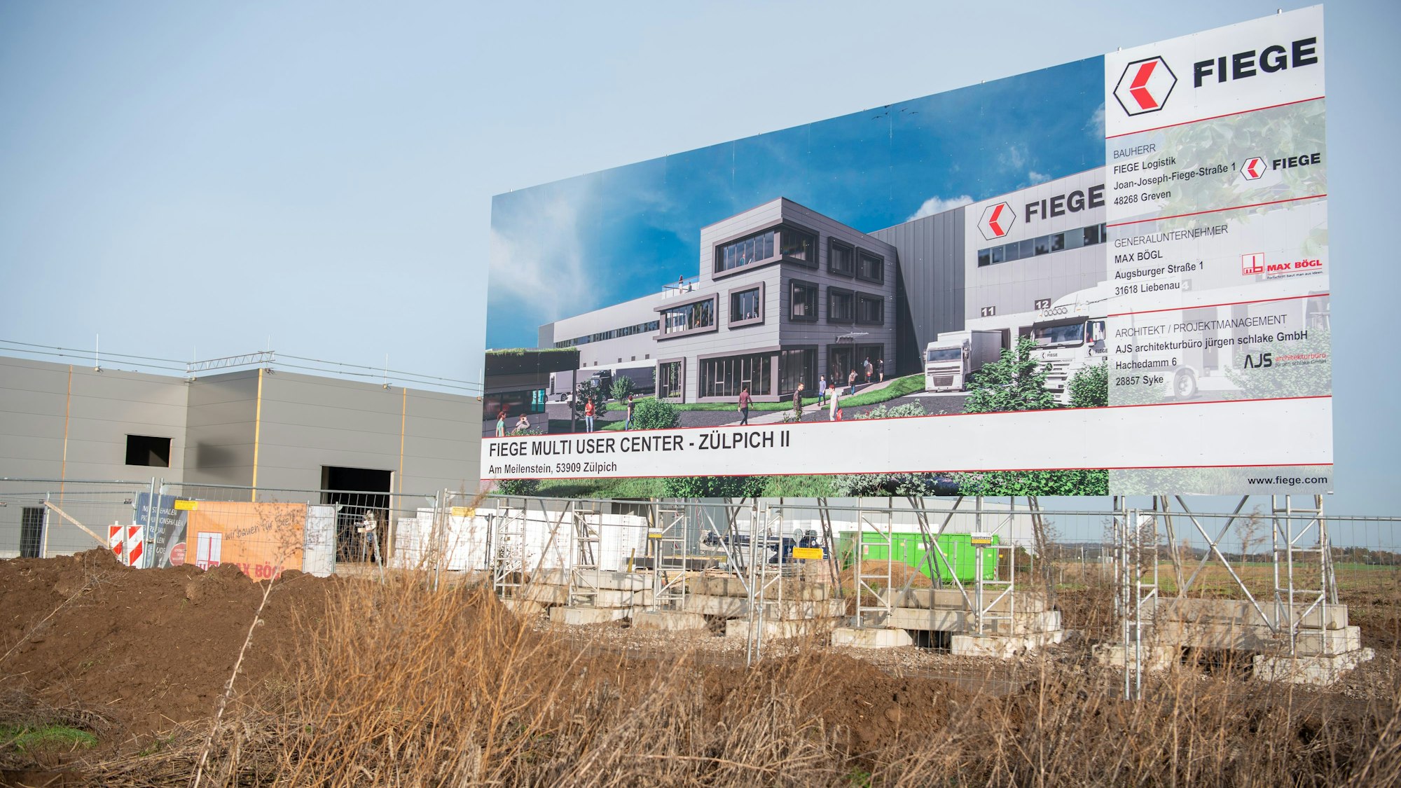 Ein großes Schild zeigt ein Bild von einem grauen Gebäude mit dem Schriftzug Fiege.