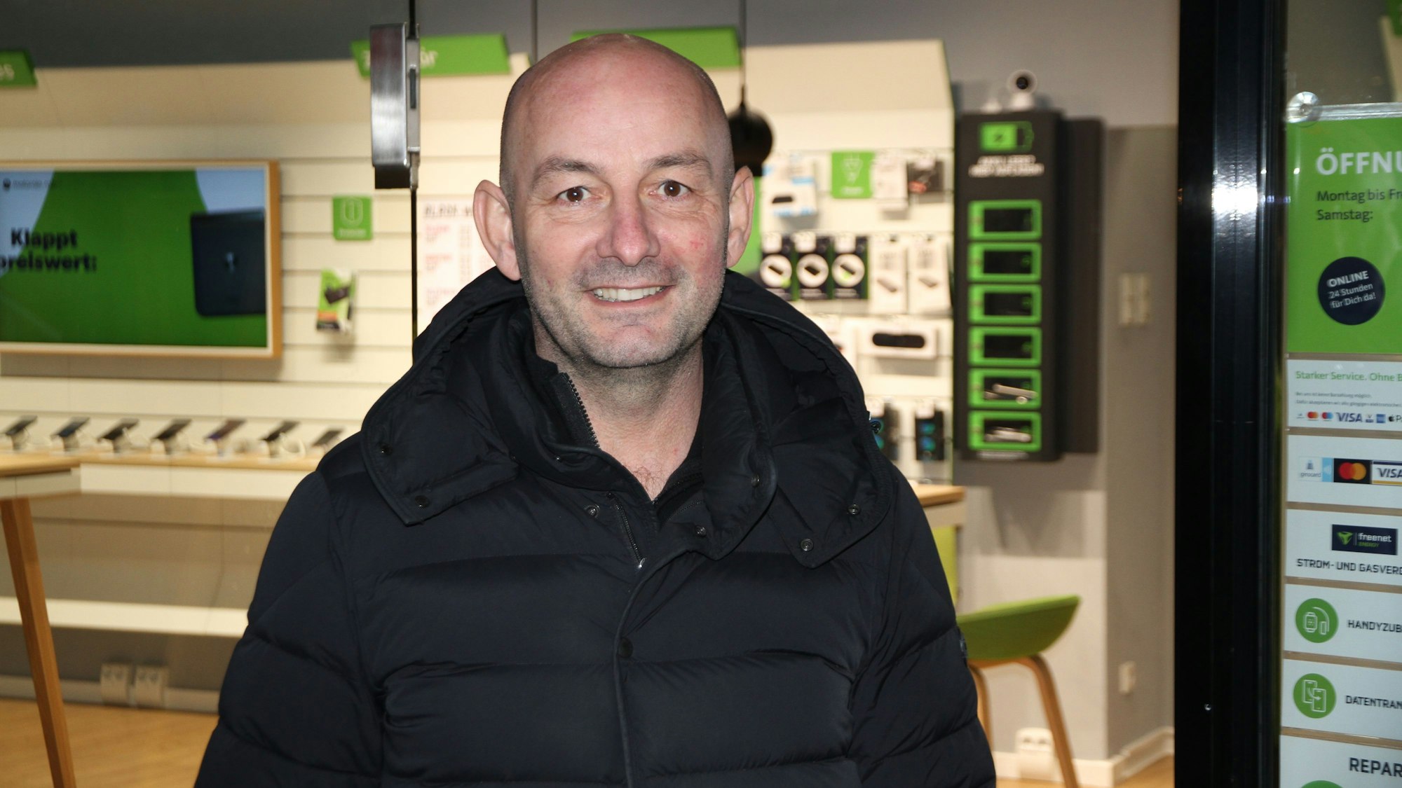 Ein Mann vor dem Schaufenster eines Telefonshops