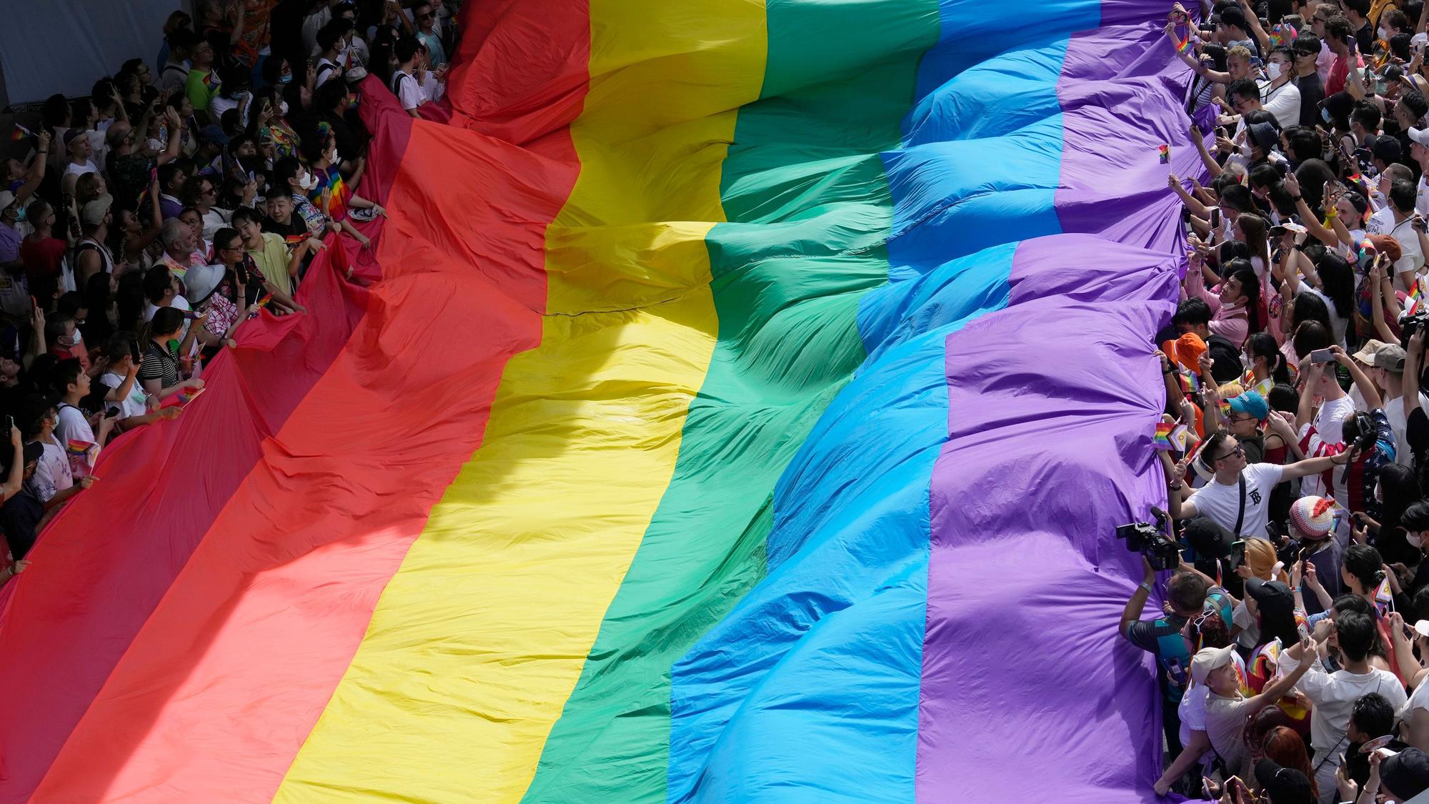 Demonstrierende halten eine Pride Flagge bei Protesten in Bangkok, Thailand.