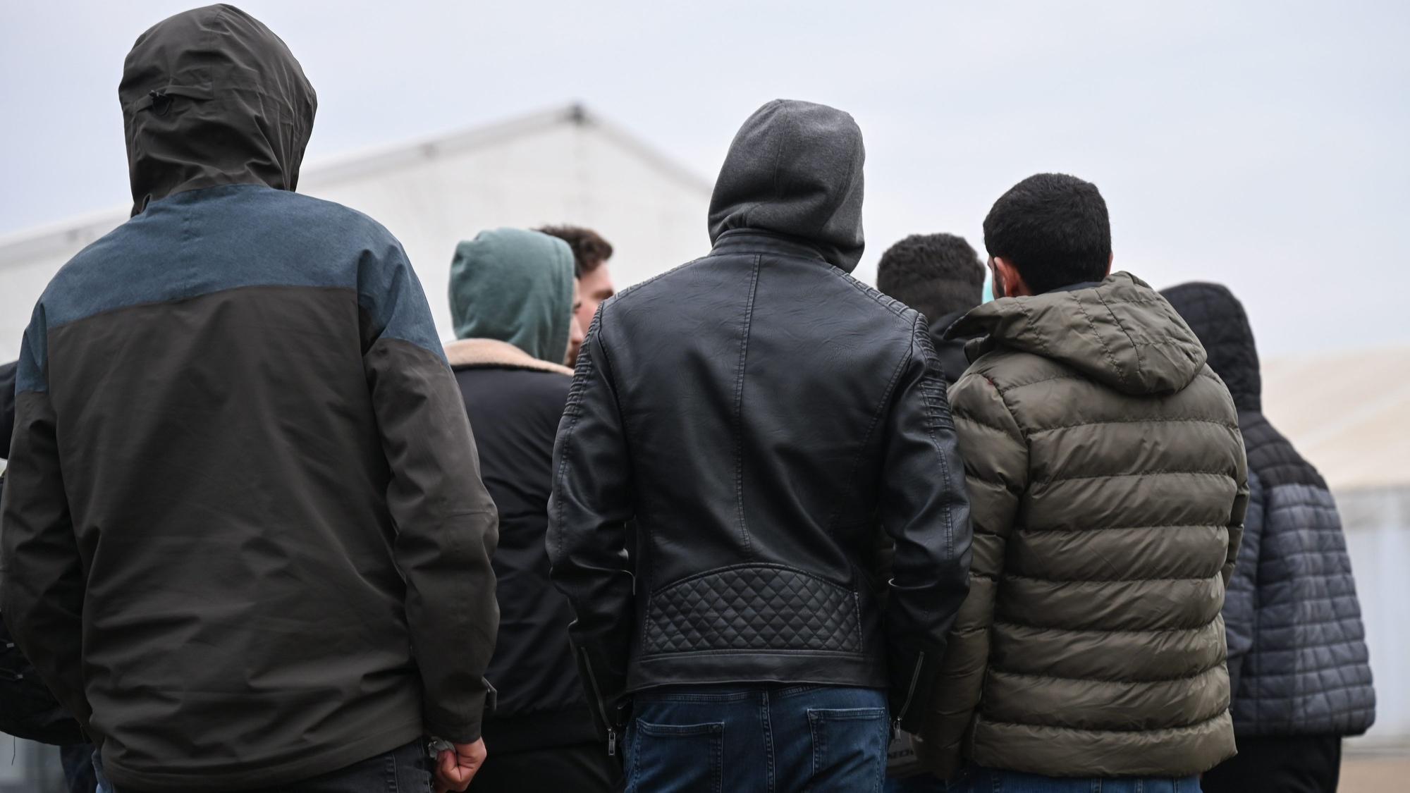 Kriegsflüchtlinge aus Syrien stehen auf dem Gelände einer Flüchtlingsunterkunft zusammen.
