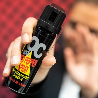 Eine Frau hält auf der Fachmesse für Jagd, Schießsport, Outdoor und Sicherheit Pfefferspray in der Hand.