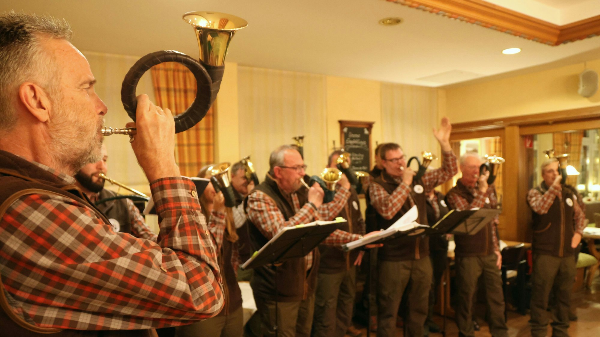 Ein Gruppe von Jagdhornbläsern folgt dem Signal ihres Leiters.