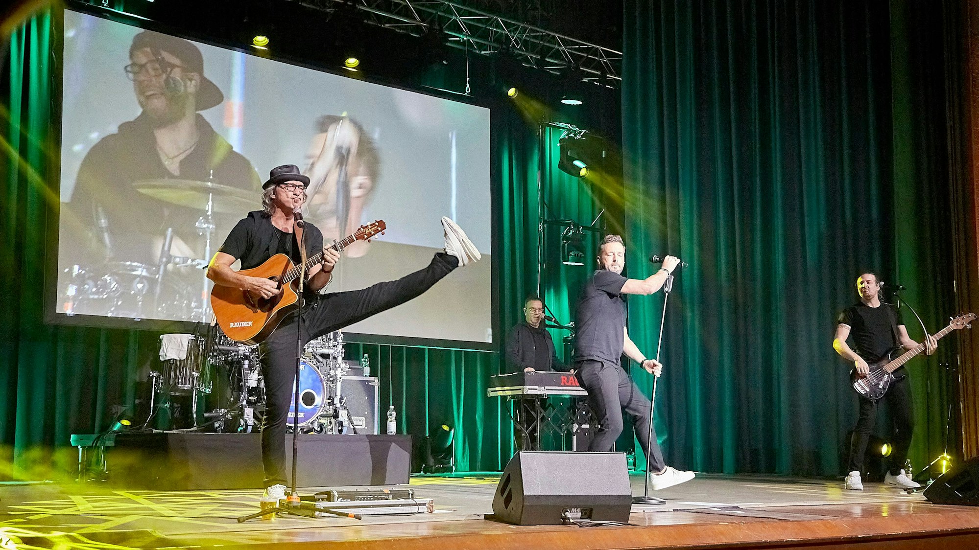 Die Räumer performen auf der Bühne vor einer Videoleinwand.