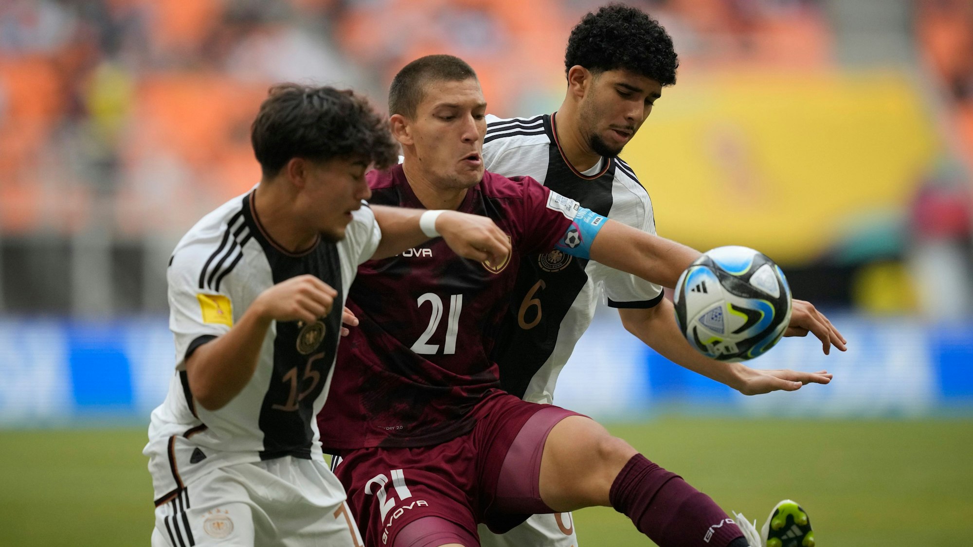 Venezuela's Nicola Profeta, center, battles for the ball against Germany's Justin von der Hitz, left, and Fayssal Harchaoui during their FIFA U-17 World Cup Group F soccer match at Jakarta International Stadium in Jakarta, Indonesia, Saturday, Nov. 18, 2023. (AP Photo/Achmad Ibrahim)
