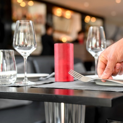 Ein Tisch wird in einem Restaurant wird eingedeckt.