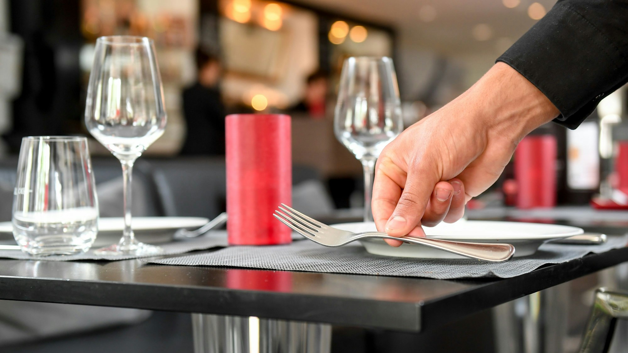 Ein Tisch wird in einem Restaurant wird eingedeckt.