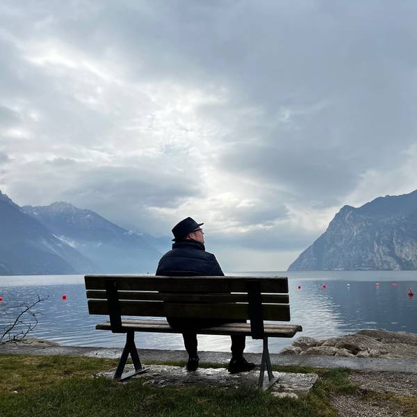 Björn Heuser sitzt auf einer Bank am Gardasee