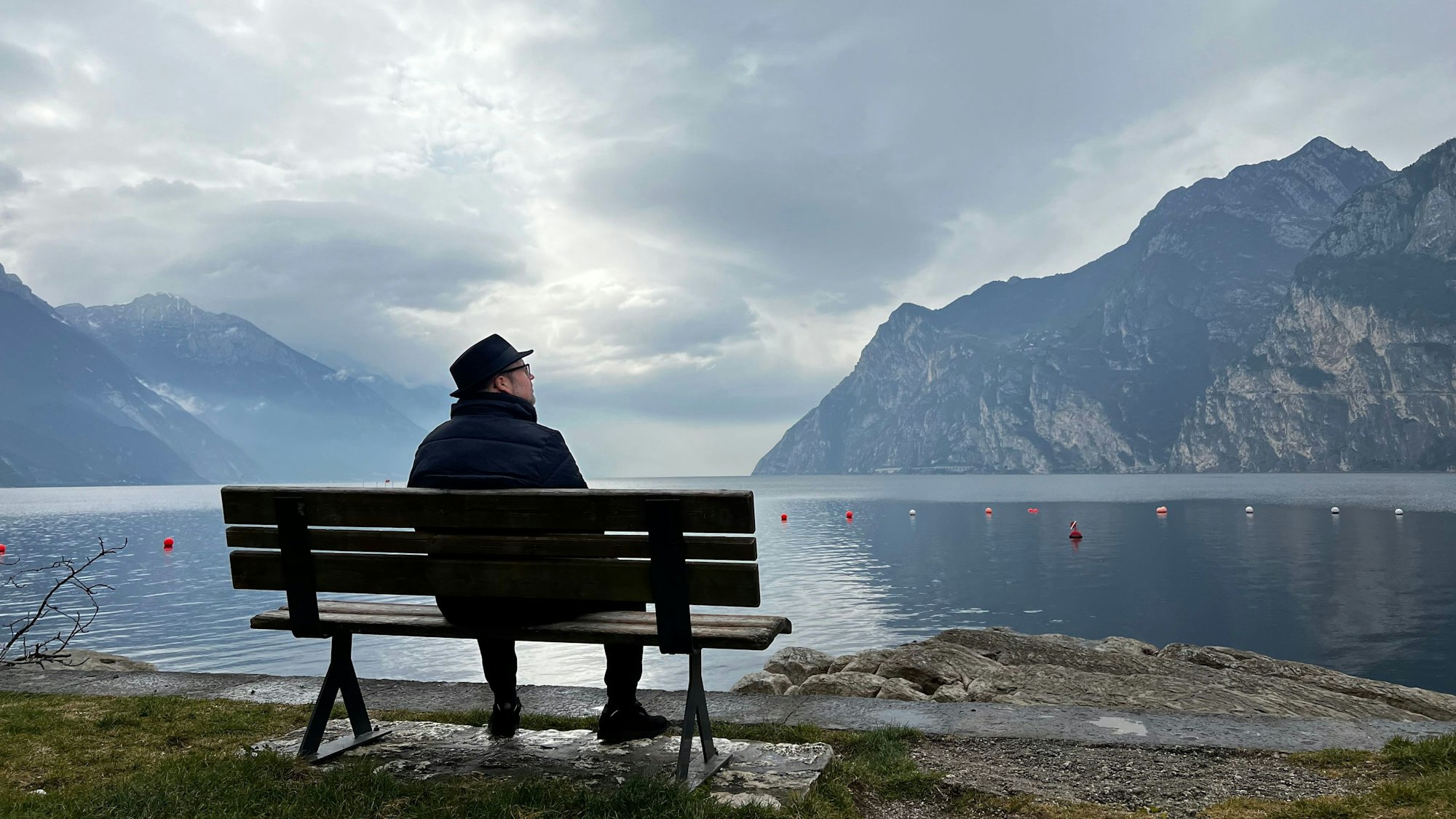 Björn Heuser sitzt auf einer Bank am Gardasee