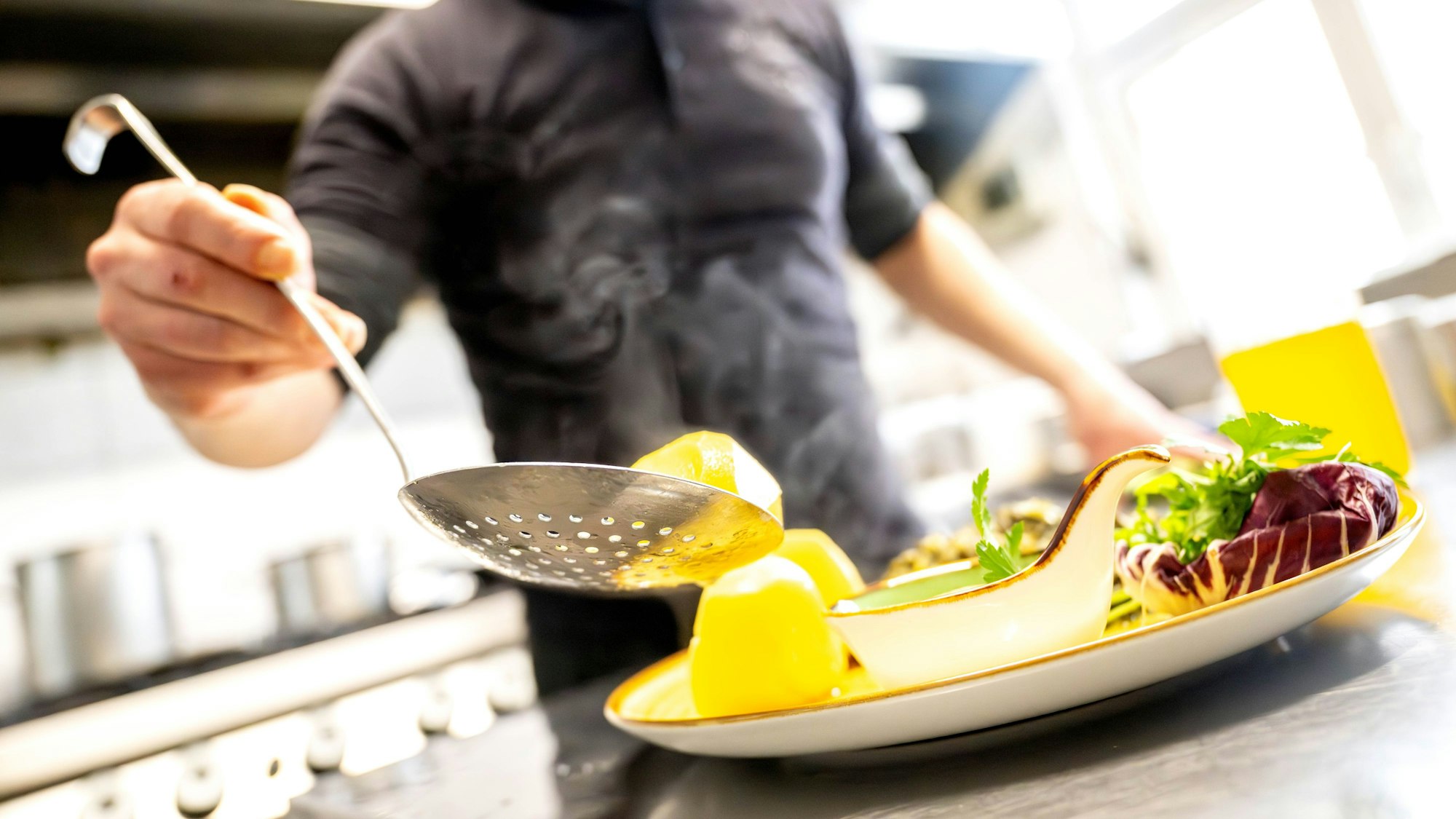 Essen wird in einem Restaurant auf einem Teller angerichtet.