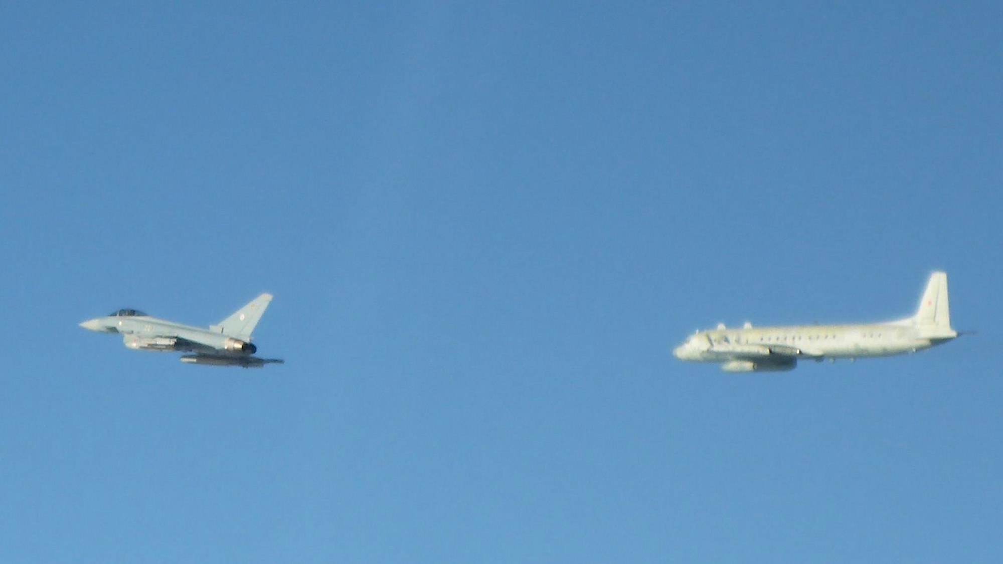 Ein Eurofighter der Alarmrotte der deutschen Luftwaffe (l.) überprüft über der Ostsee ein russisches Militärflugzeug vom Typ Iljuschin IL-20 (r.). Das russische Flugzeug war unangekündigt in NATO-Luftraum eingedrungen. (Archivbild)