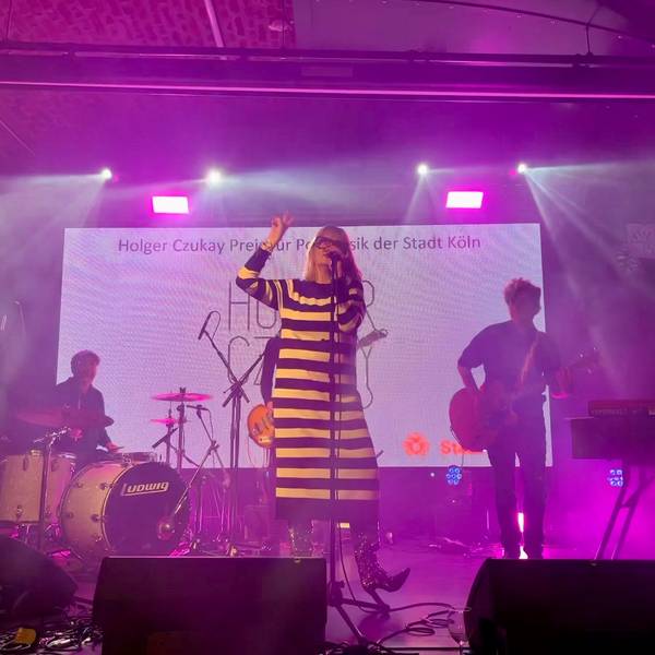 Band Klee beim Holger-Czukay-Preis 2023: Sängerin Suzie Kerstgens trägt ein schwarz-weiß-quergestreiftes Strickkleid.