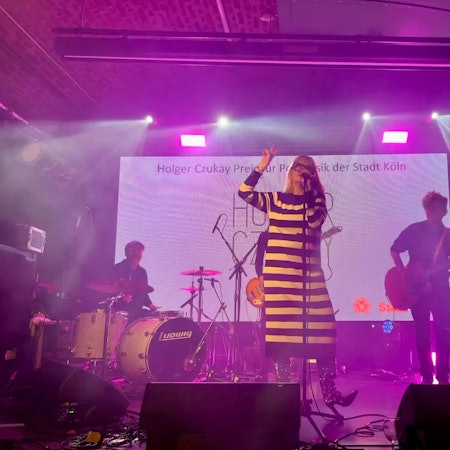 Band Klee beim Holger-Czukay-Preis 2023: Sängerin Suzie Kerstgens trägt ein schwarz-weiß-quergestreiftes Strickkleid.