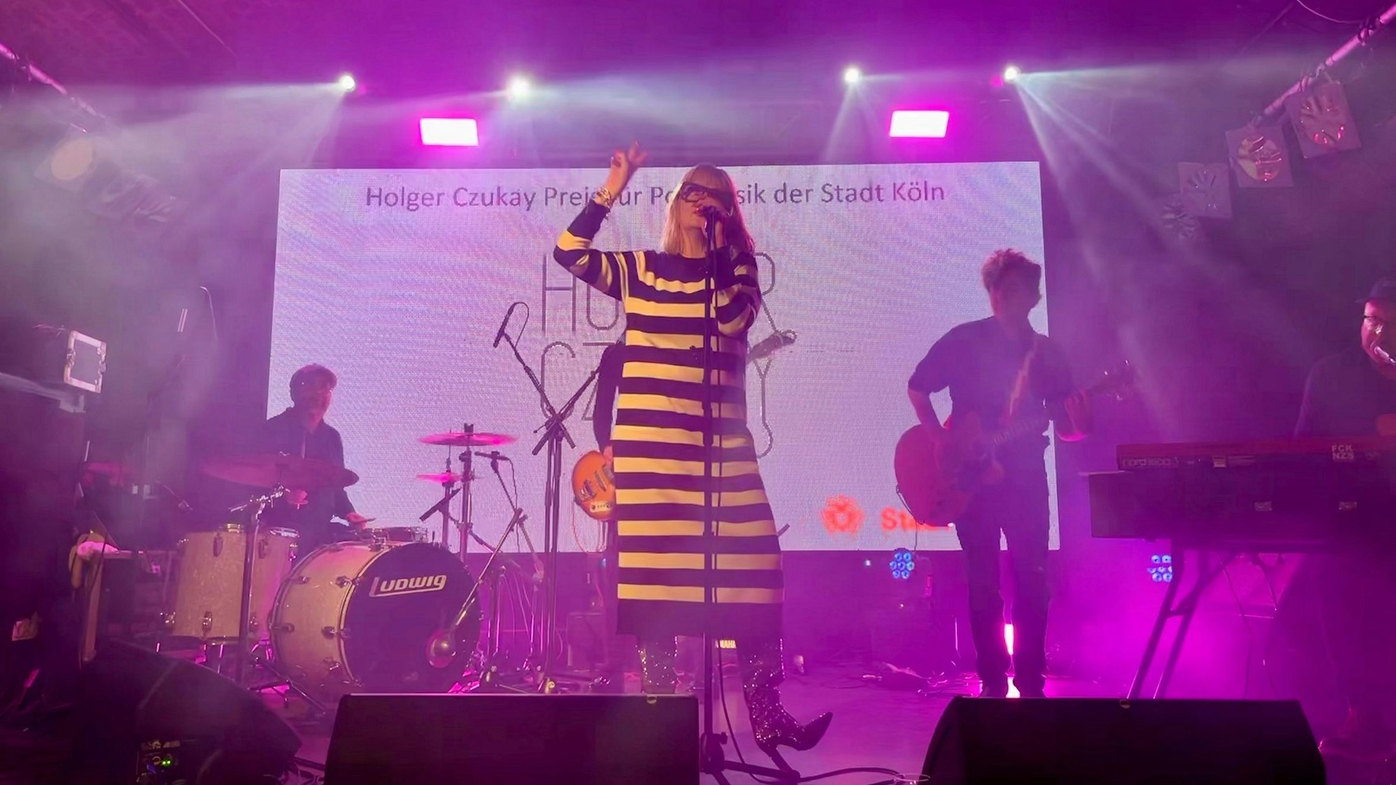 Band Klee beim Holger-Czukay-Preis 2023: Sängerin Suzie Kerstgens trägt ein schwarz-weiß-quergestreiftes Strickkleid.