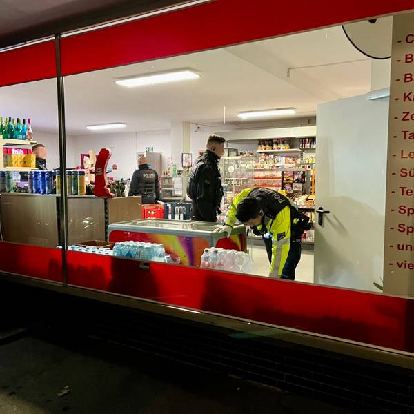 Mitarbeitende von Polizei und Ordnungsamt durchsuchen einen Kiosk in Rheindorf.