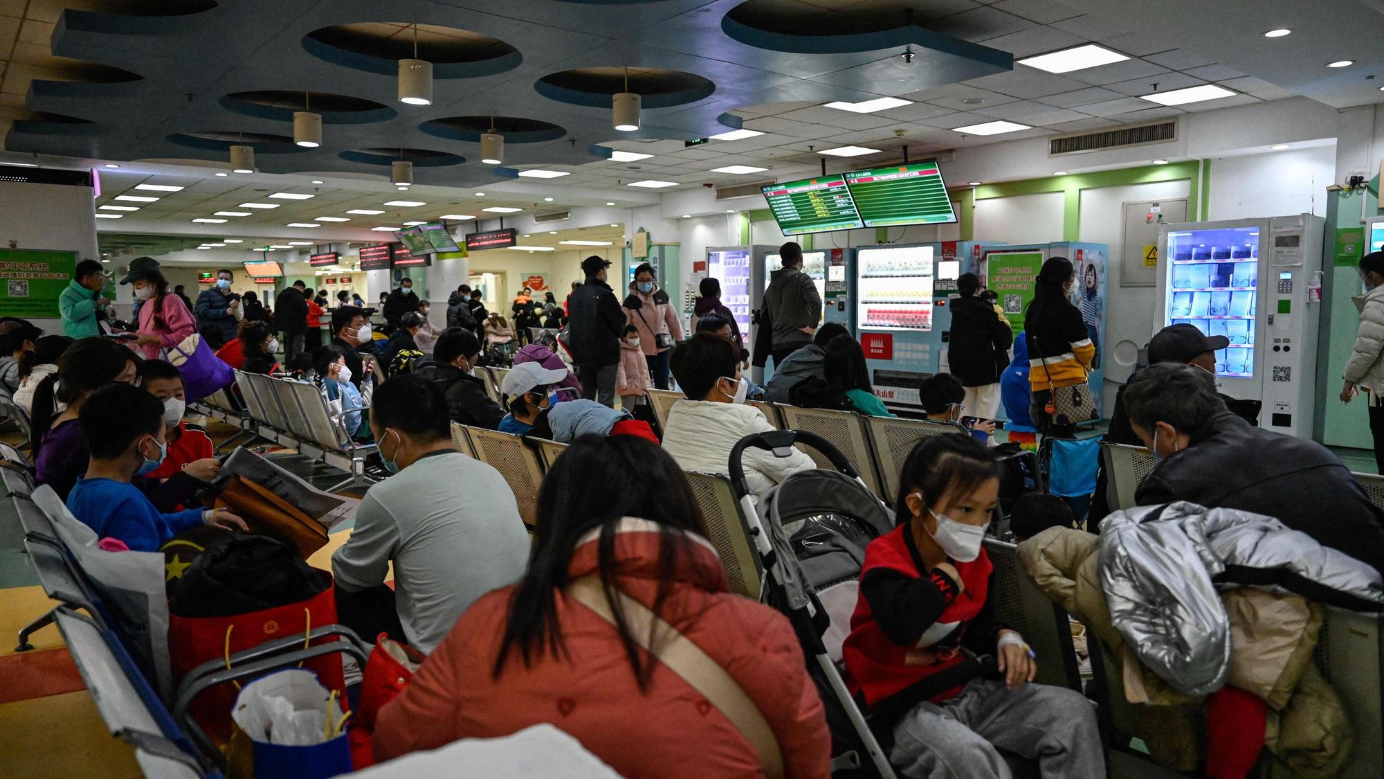 Kinder und ihre Eltern warten am 23. November 2023 in einem ambulanten Bereich eines Kinderkrankenhauses in Peking.