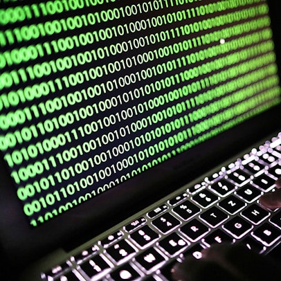 Auf dem Bildschirm eines Laptops ist ein Binärcode zu sehen.