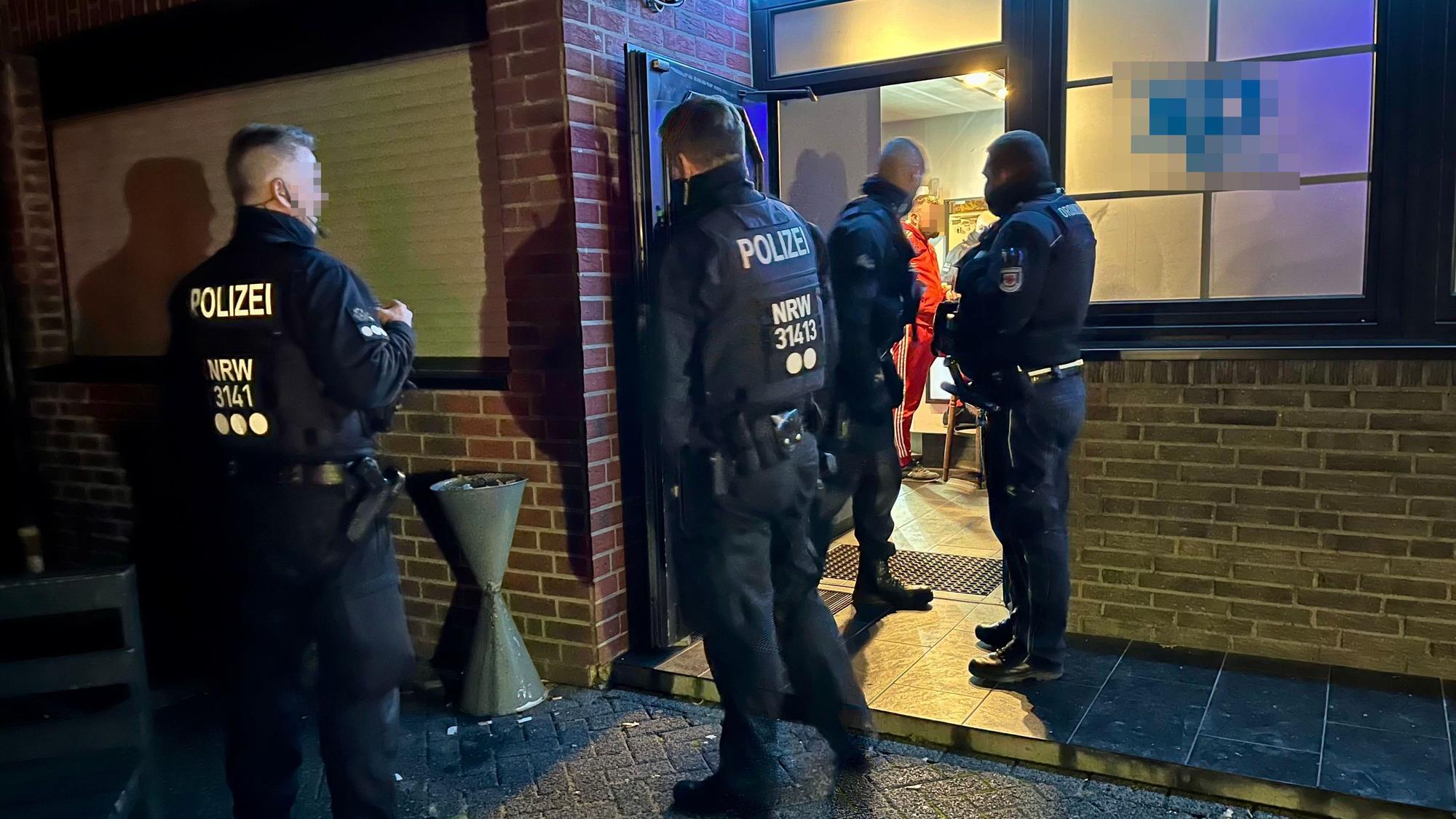 Polizisten betreten eine Bar.