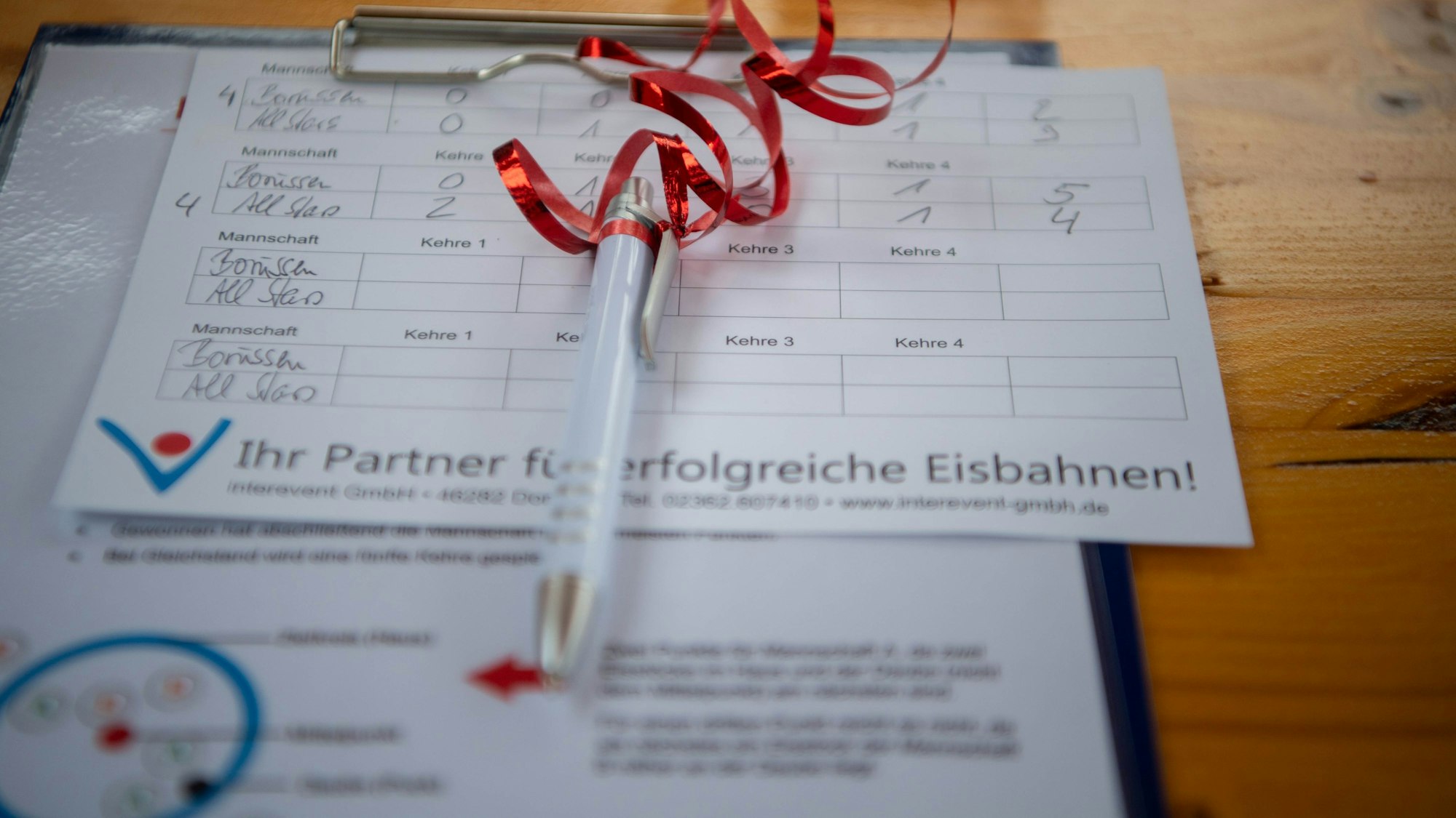 Das Bild zeigt einen Ergebniszettel mit einem Stift.