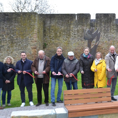 Zahlreiche Menschen durchschneiden zur Eröffnung des Bad Münstereifeler Europaplatzes ein rotes Band.