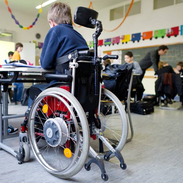 Ein Junge im Rollstuhl sitzt in einem Klassenzimmer.