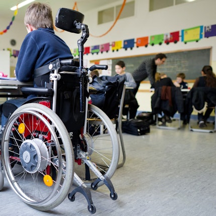 Eine Junge im Rollstuhl in einem Klassenzimmer.