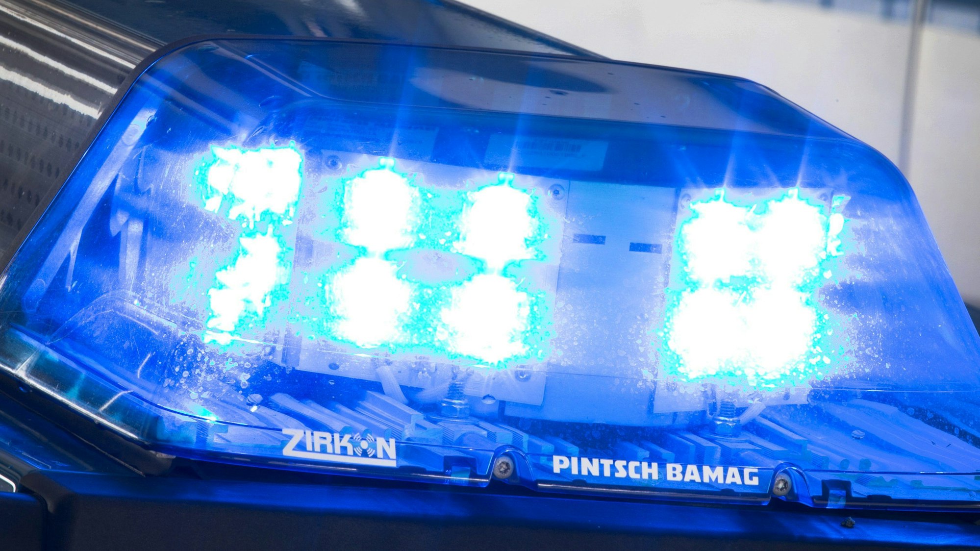 Eine Blaulicht leuchtet auf dem Dach eines Polizeiwagens.