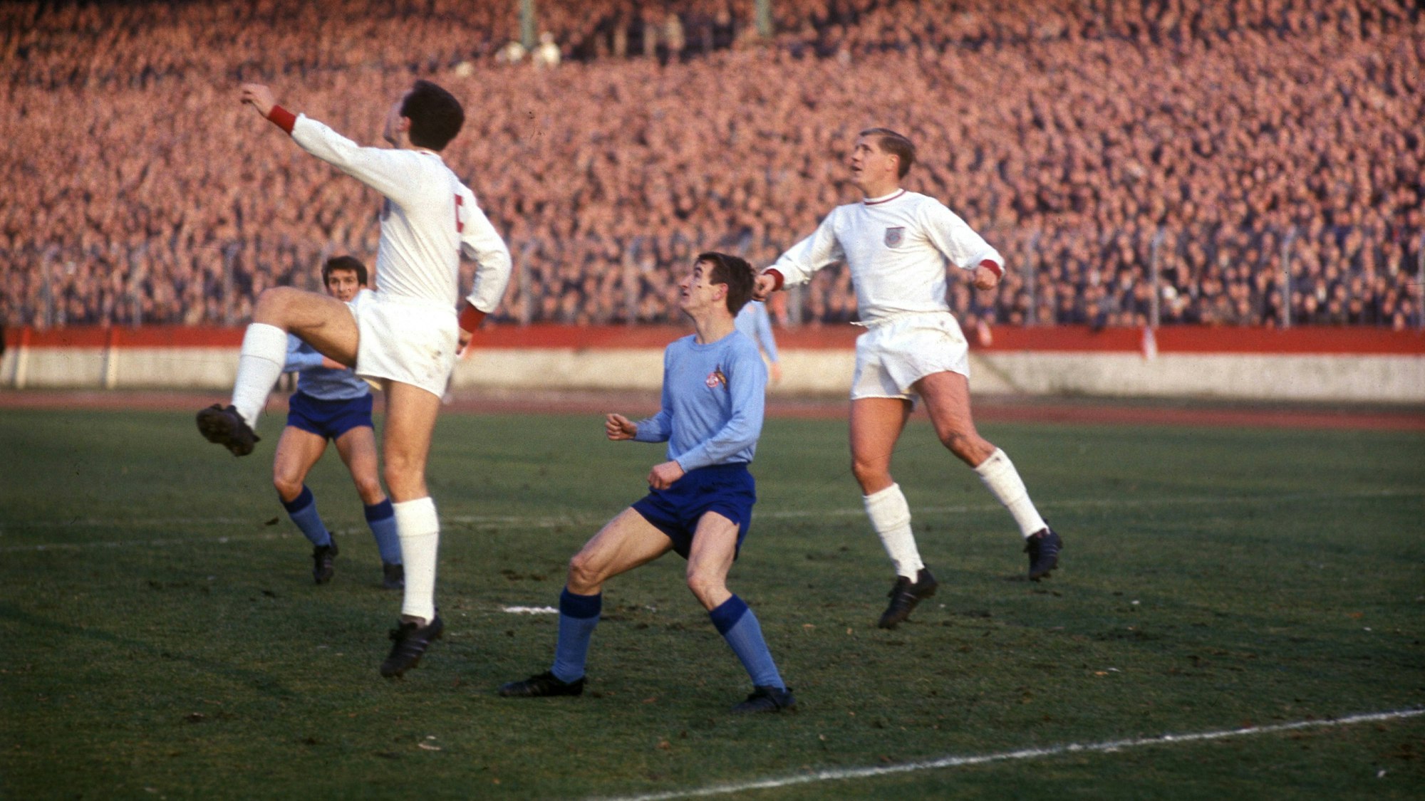 Spieler des 1. FC Köln in ungewohntem Himmelblau kämpfen mit Spielern des FC Bayern München um den Ball.