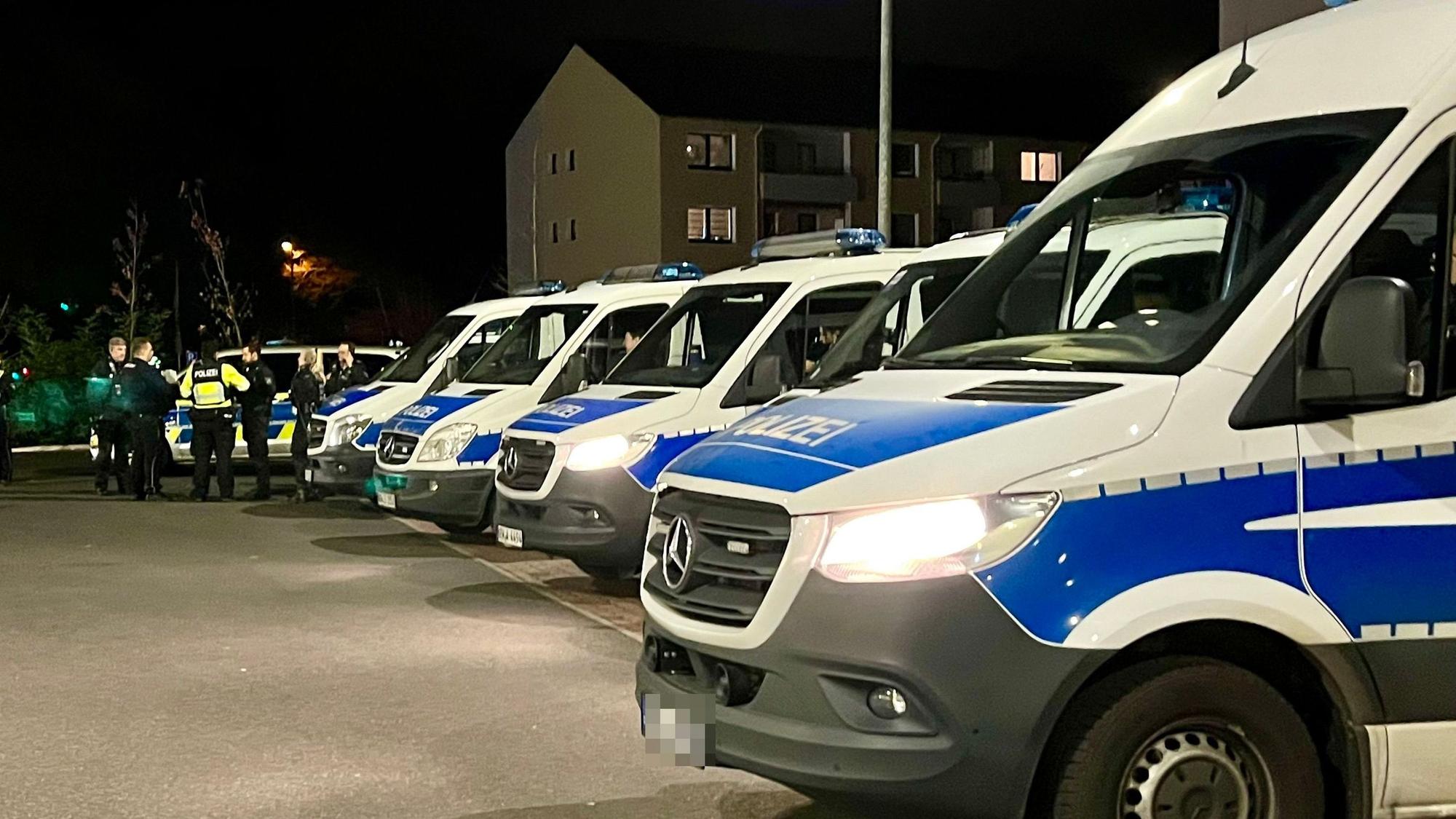 Viele Polizeiwagen und Beamte auf einem Parkplatz