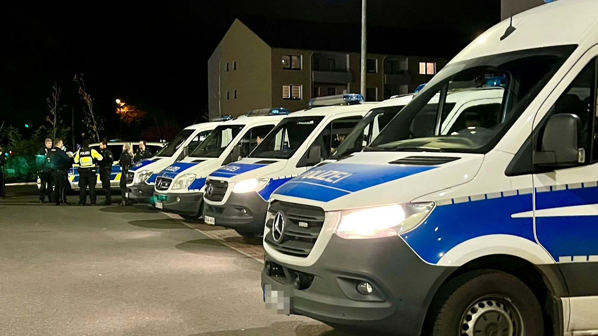 Viele Polizeiwagen und Beamte auf einem Parkplatz