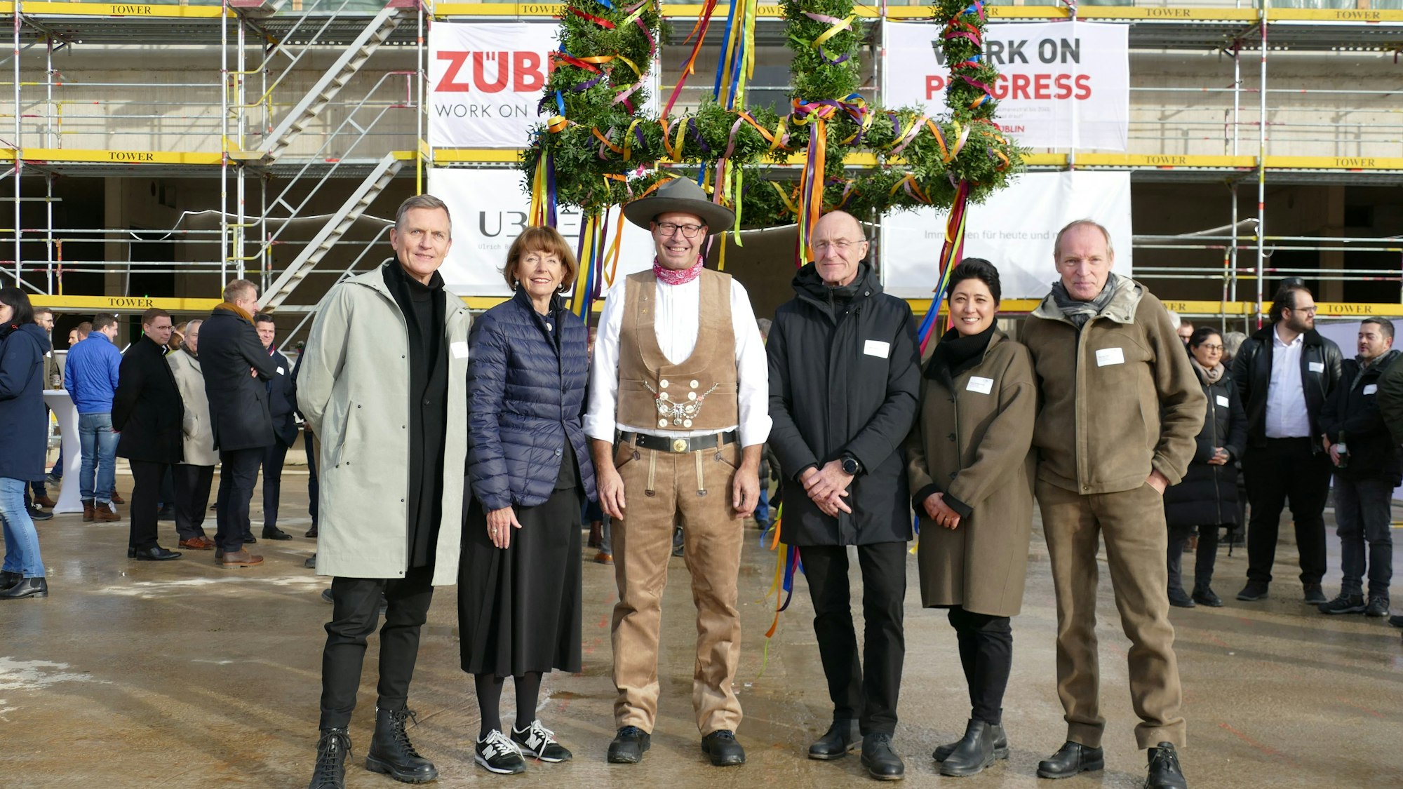 Die Bürgermeisterin, der Architekt und der Investor stehen vor dem Rohbau.