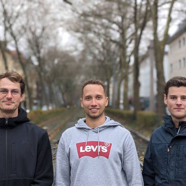 Max Krumm, Geronimo Pfeffer und Michel Sayn stehen auf einer Straße in Köln.