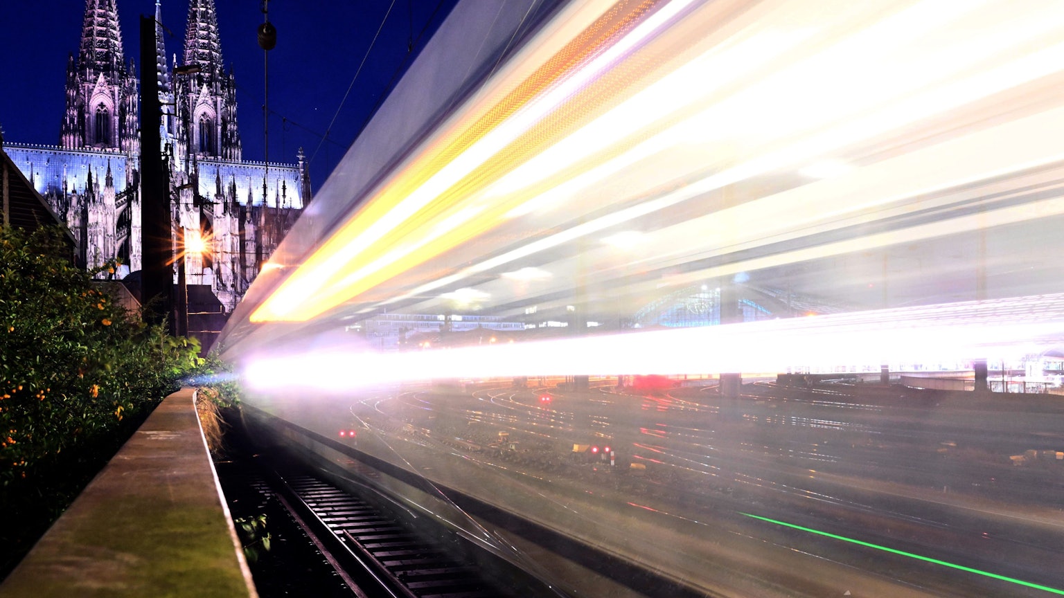 Ein Zug fährt am frühen Morgen am Dom vorbei.