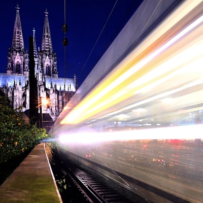 Ein Zug fährt am frühen Morgen am Dom vorbei.