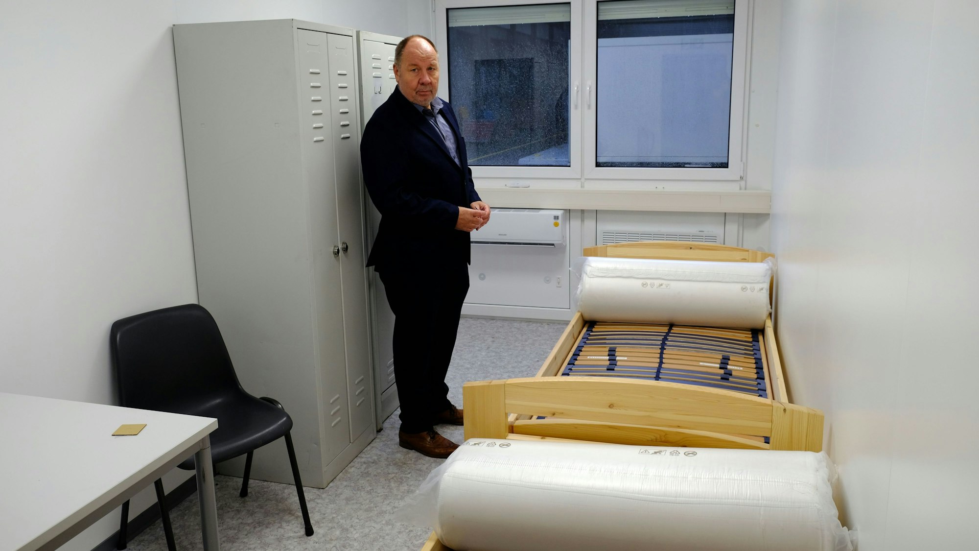 Mechatronics-Geschäftsleiter Jürgen Carl in einem der Wohncontainer, die mit zwei Betten, Schränken und Tisch ausgestattet sind.