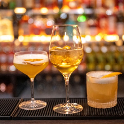 Drei Getränke stehen auf dem Tresen einer Bar.