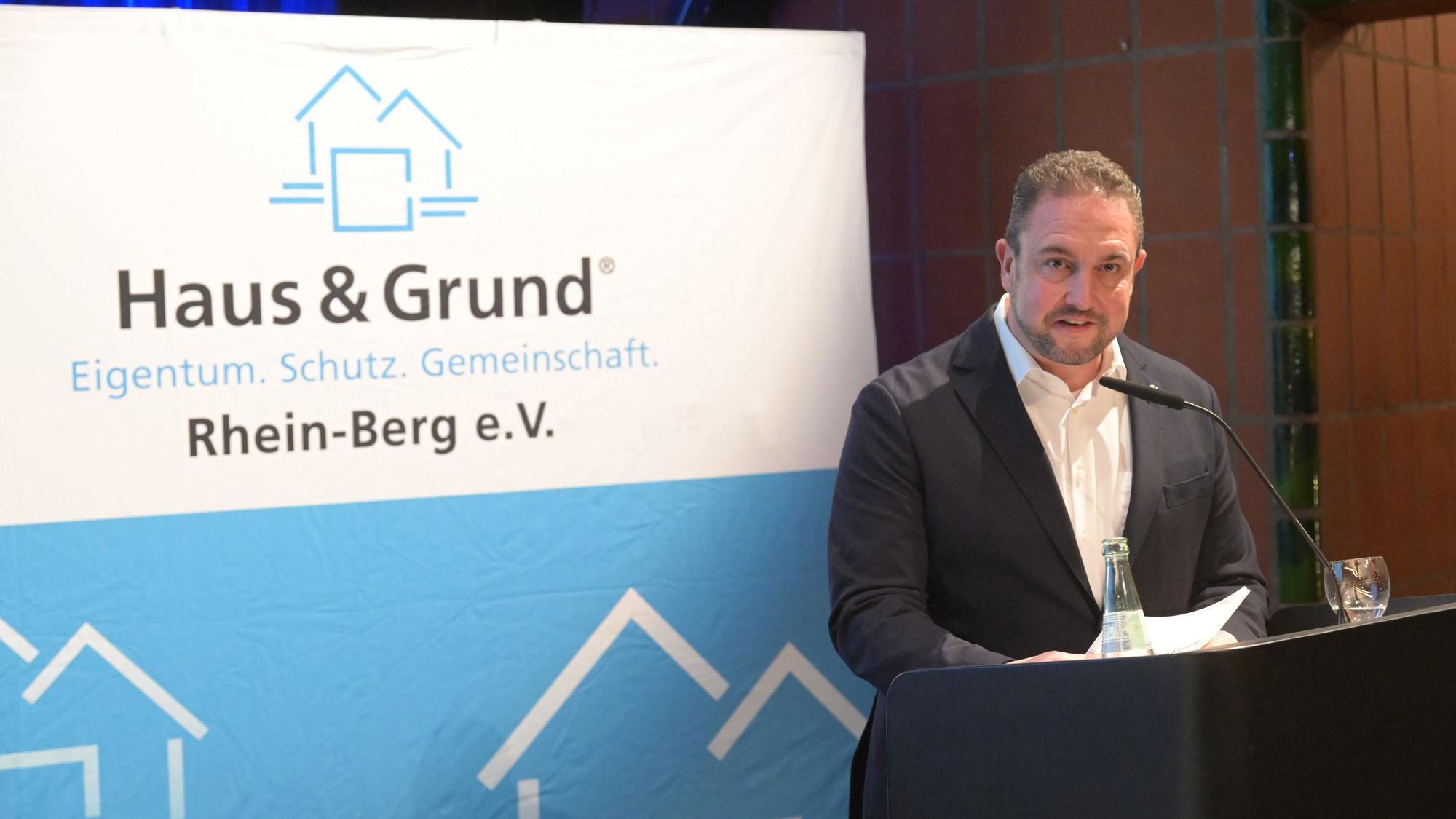 Sebastian Feik steht am Rednerpult von Haus & Grund Rhein-Berg.