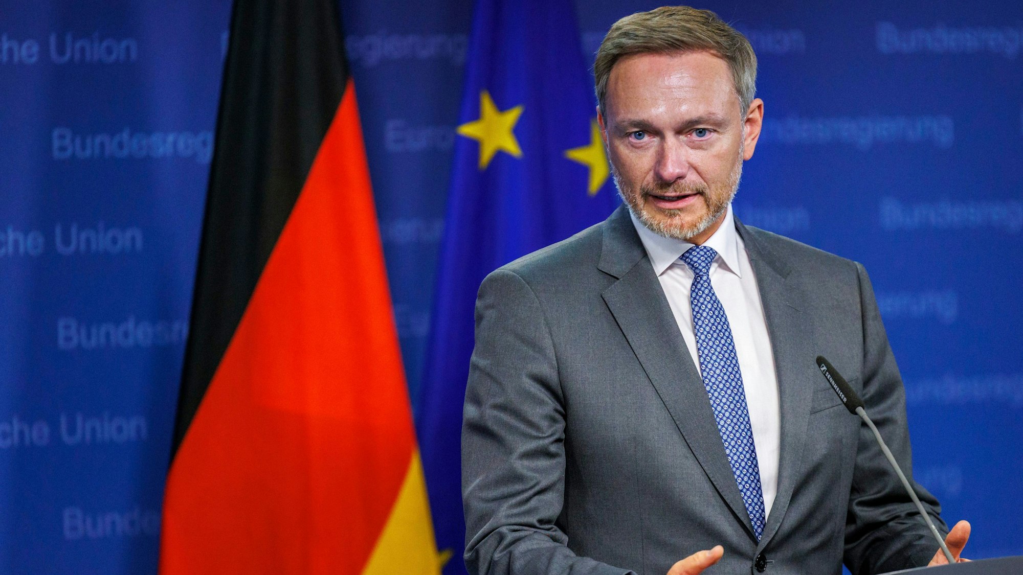 Bundesfinanzminister Christian Lindner (FDP) steht an einem Rednerpult, im Hintergrund sind Deutschland- und Europaflagge zu sehen.