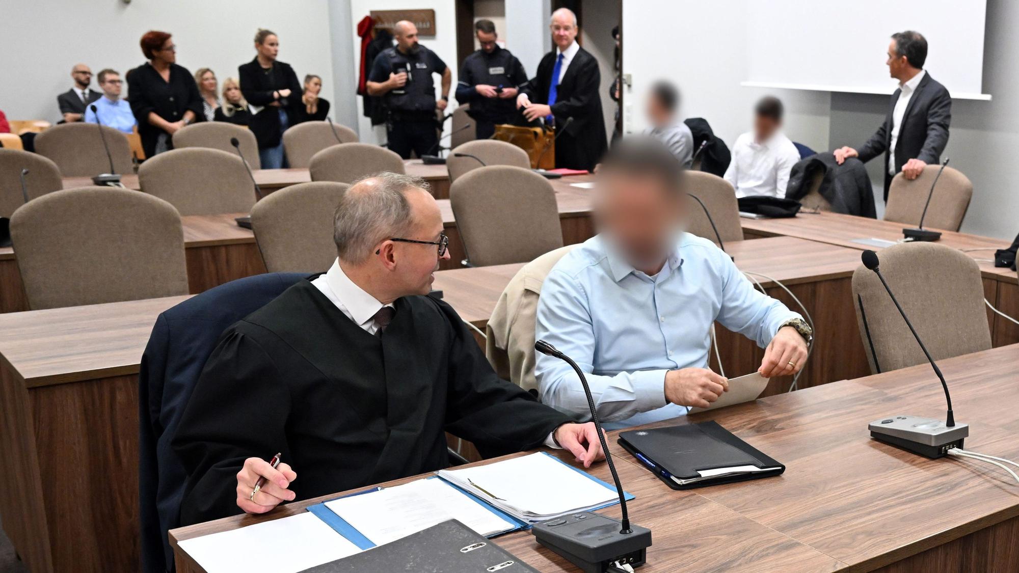 Die beschuldigten Polizisten mit ihren Verteidigern beim Prozessauftakt im Landgericht Köln.