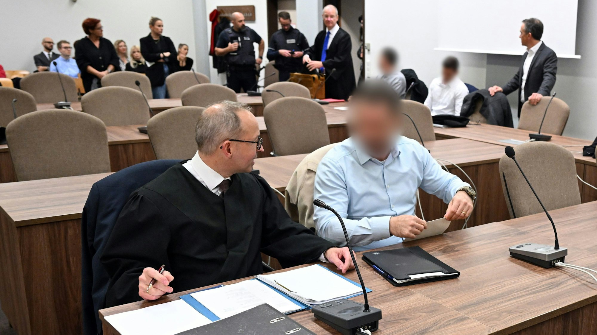 Die beschuldigten Polizisten mit ihren Verteidigern beim Prozessauftakt im Landgericht Köln.