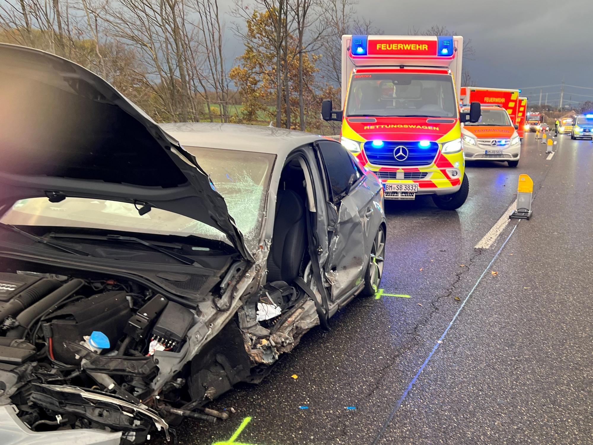 Das Bild zeigt einen beschädigten Pkw und mehrere Rettungswagen.