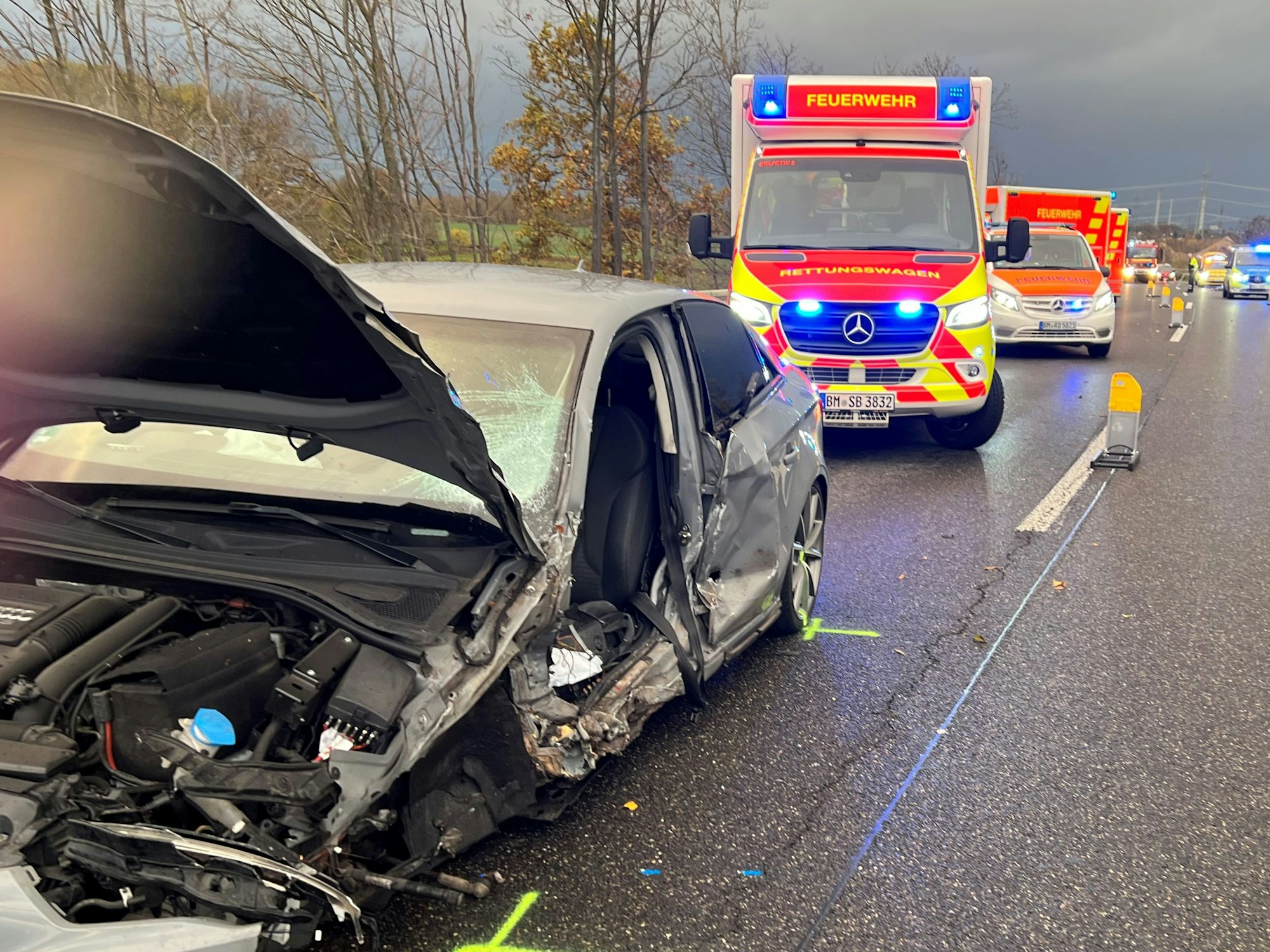 Das Bild zeigt einen beschädigten Pkw und mehrere Rettungswagen.