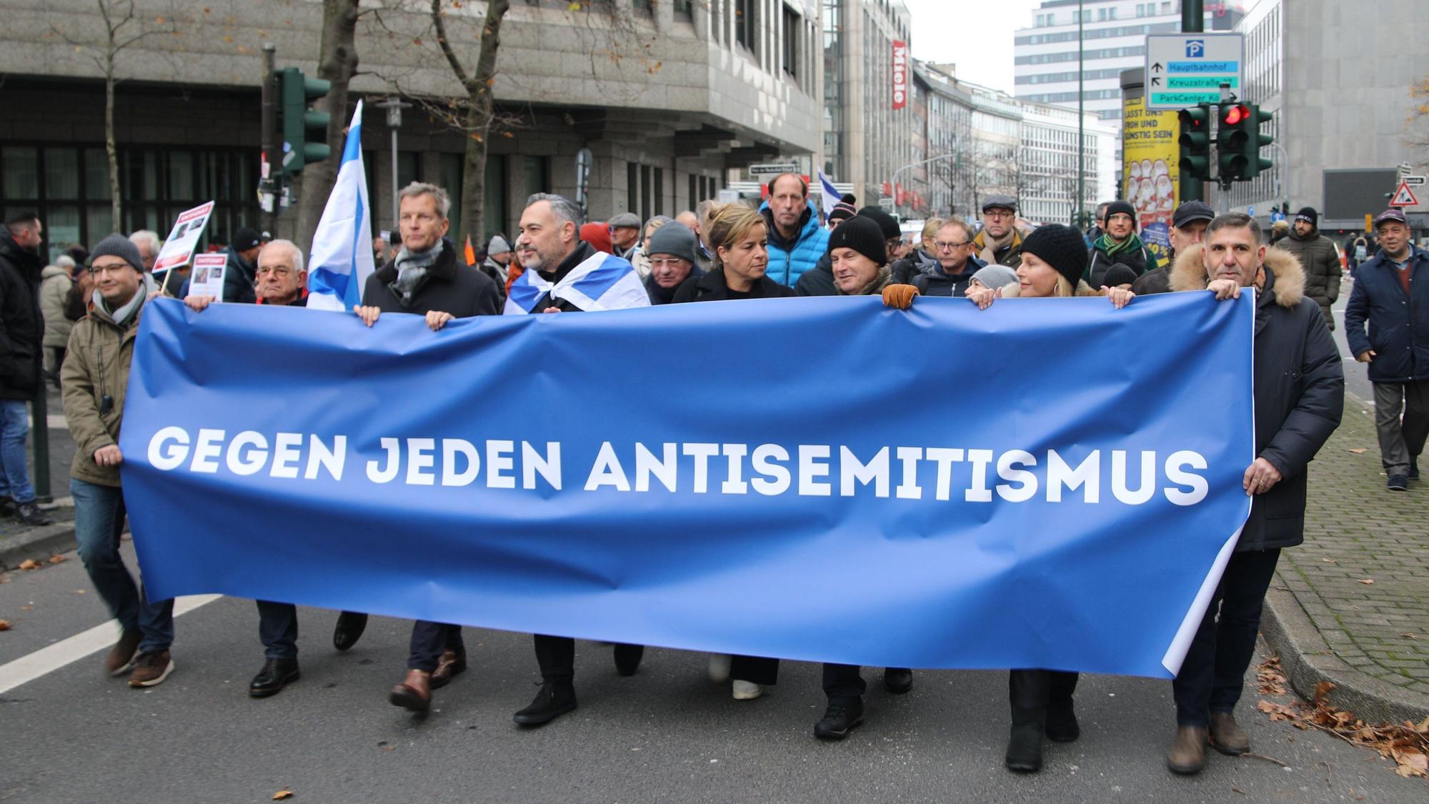 Teilnehmer des Friedensmarsch gegen Antisemitismus, zu dem die Jüdische Gemeinde eingeladen hatte, tragen ein Banner mit der Aufschrift "Gegen jeden Antisemitismus".