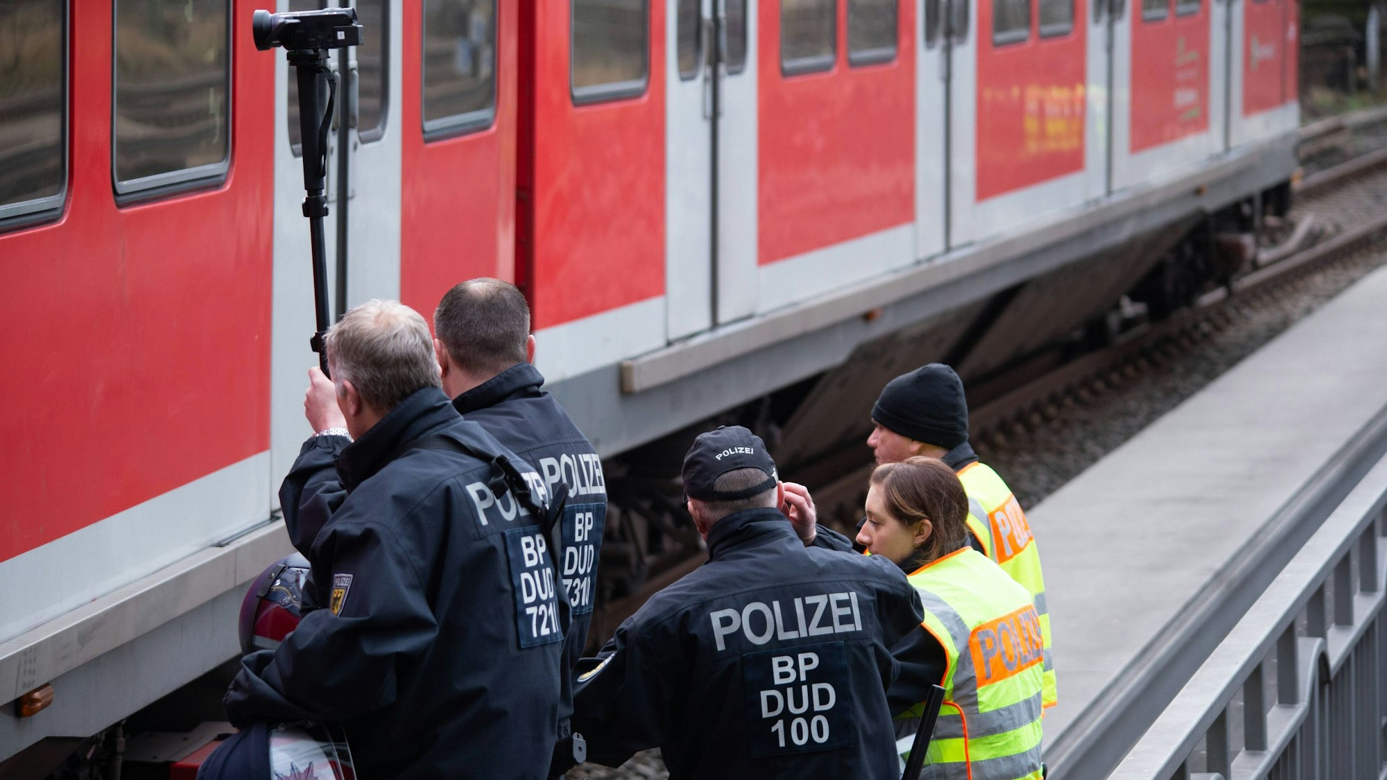 Bundespolizistinnen und -polizisten stehen an einem Bahngleis. Am Samstagabend (25. November) sind Anhänger des 1. FC Köln und Schalke 04 in Düsseldorf aufeinander losgegangen. (Symbolbild)