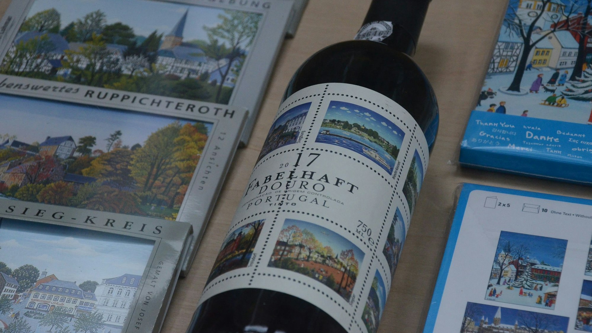 Grußkarten und eine Flasche Wein aus dem Douro-Tal in Portugal zeigen Illustrationen von Josef Hawle.