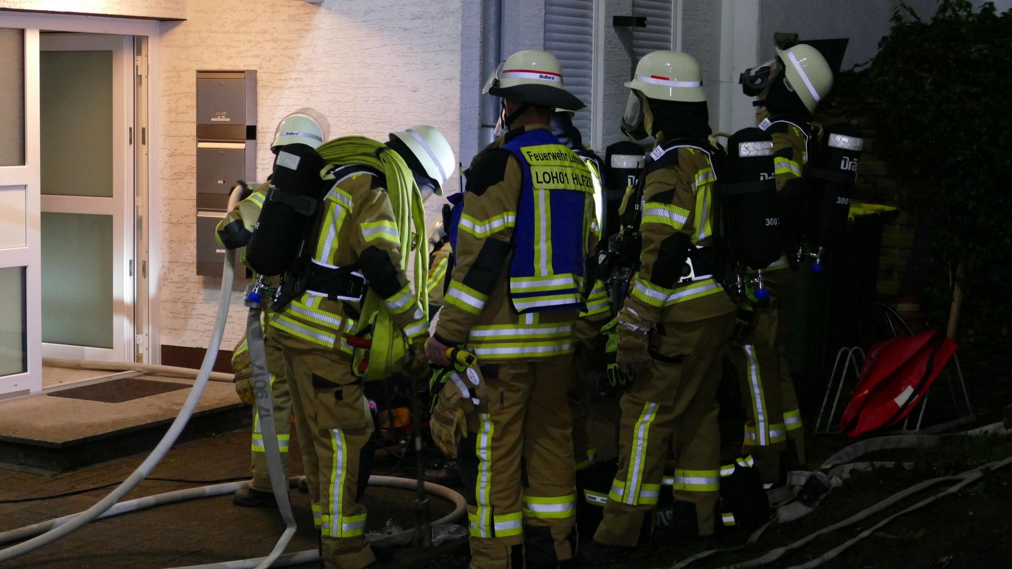 Feuerwehrleute vor dem Eingang zu dem Mehrparteienhaus.
