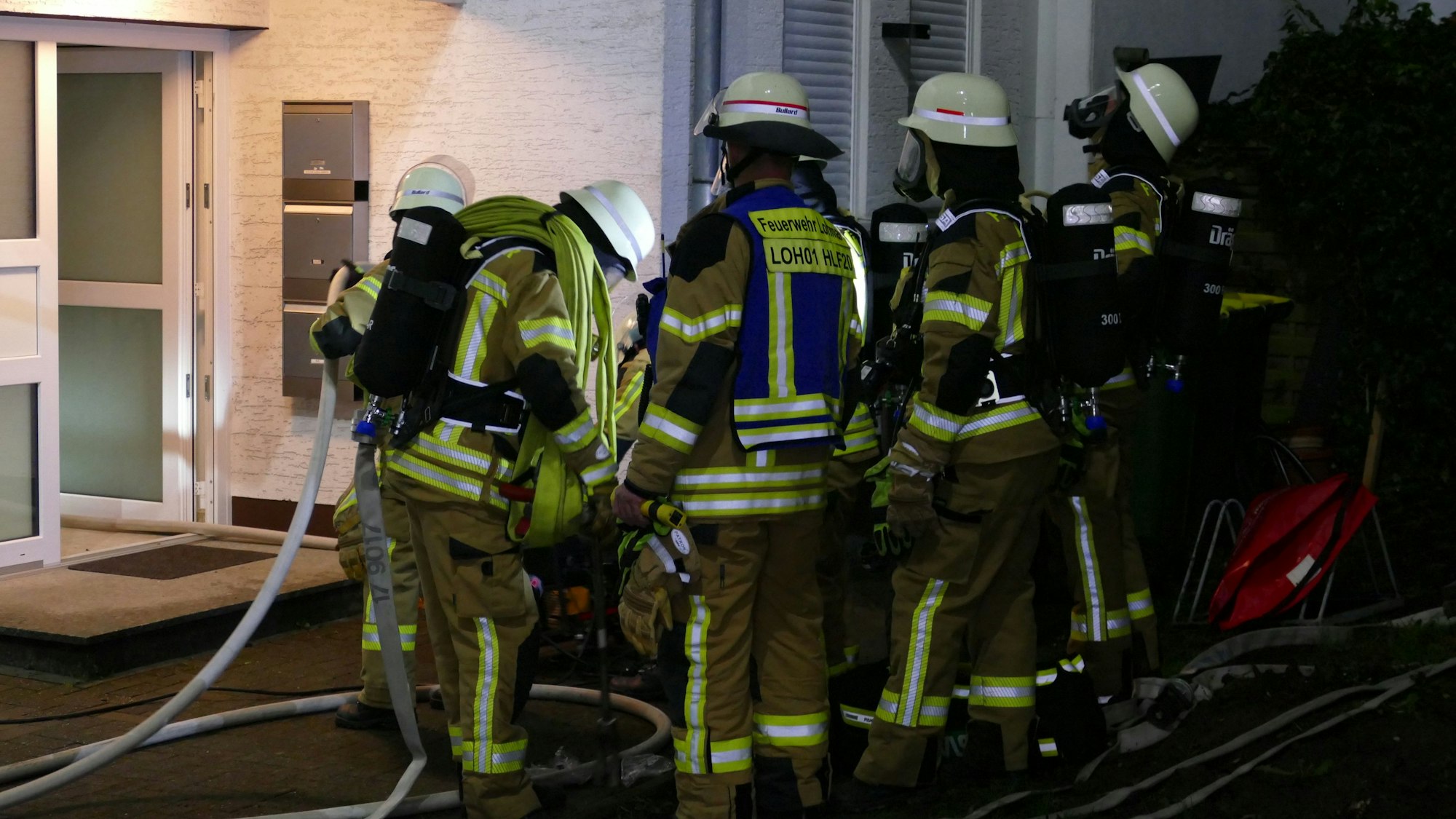 Feuerwehrleute vor dem Eingang zu dem Mehrparteienhaus.