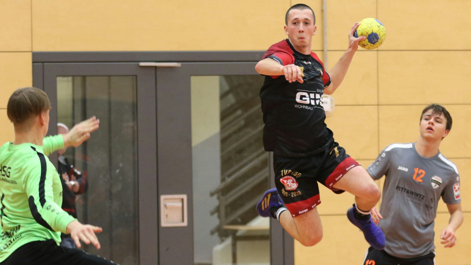 Palmersheims Timo Johnen steigt mit dem Ball in der Hand zum Sprung hoch. Ein Gegenspieler schaut zu, der Torwart hält eine Hand hoch.